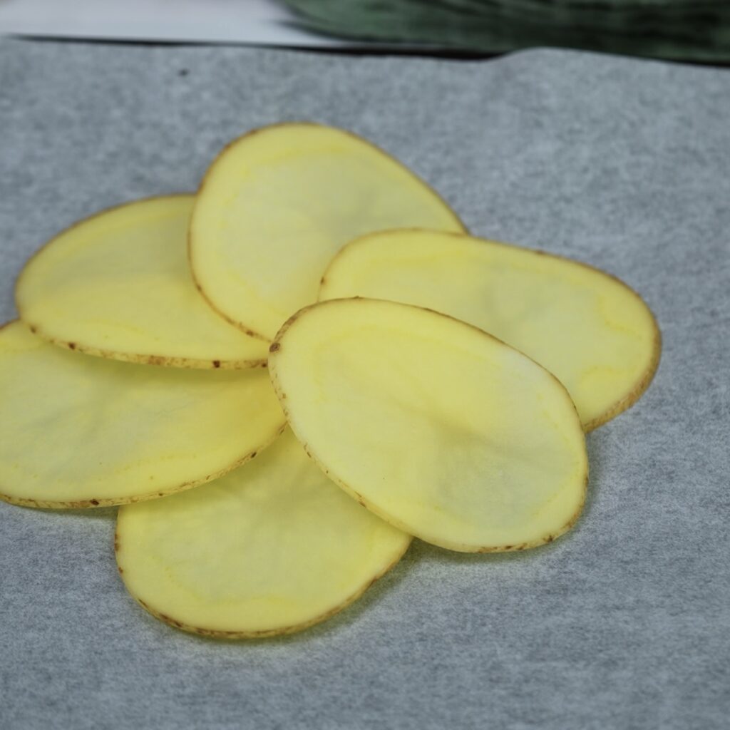 Potato slices beautifully arranged in a flower shape on a baking tray