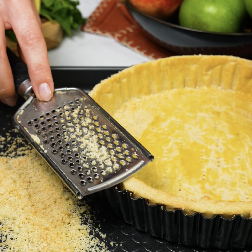 Using a grater to smooth the tart edges.