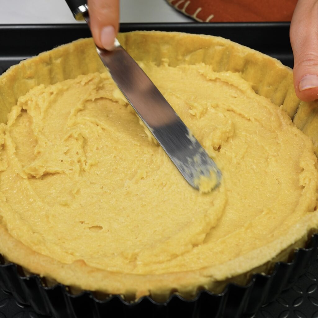 Spreading frangipane into the tart crust.