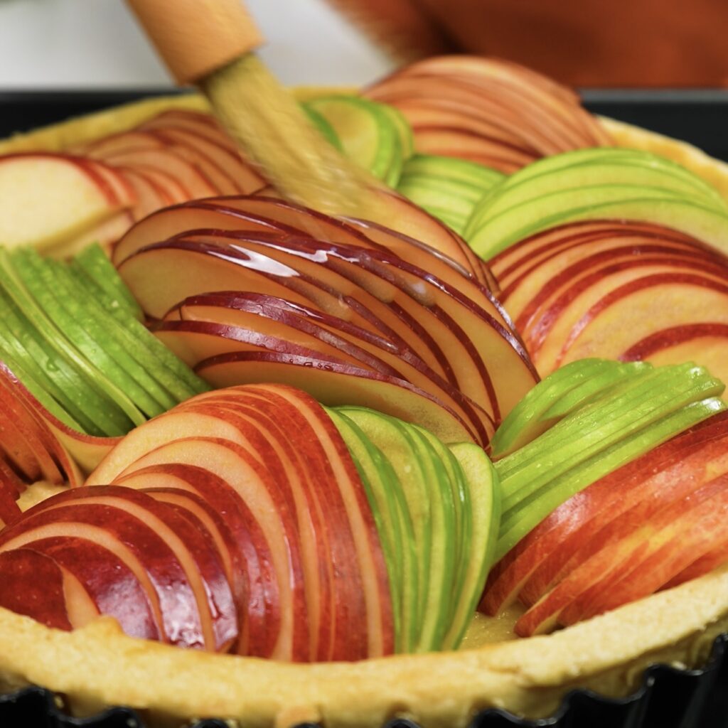 Brushing sliced apples with melted butter.