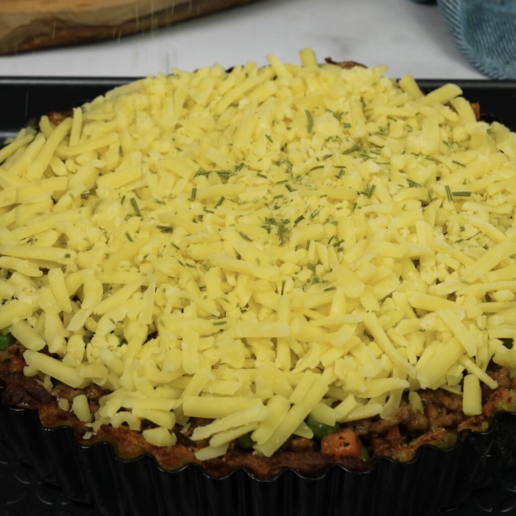 Crushed Potato Cottage Pie topped with cheddar cheese and fresh rosemary.