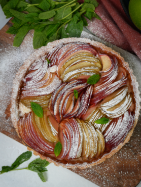 Whole Apple Bakewell Tart with golden crust and apple slices.