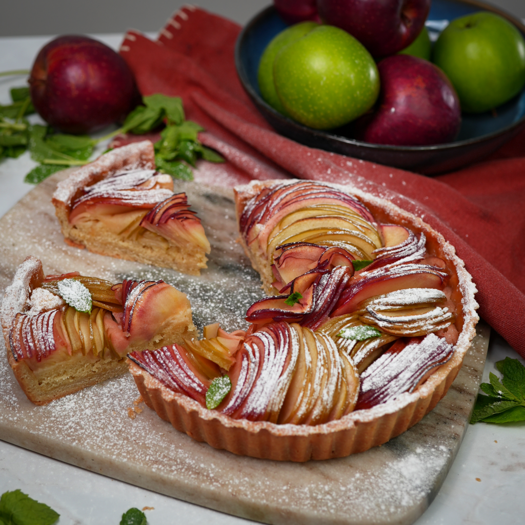 Sliced Apple Bakewell Tart with almond frangipane and baked apple topping.