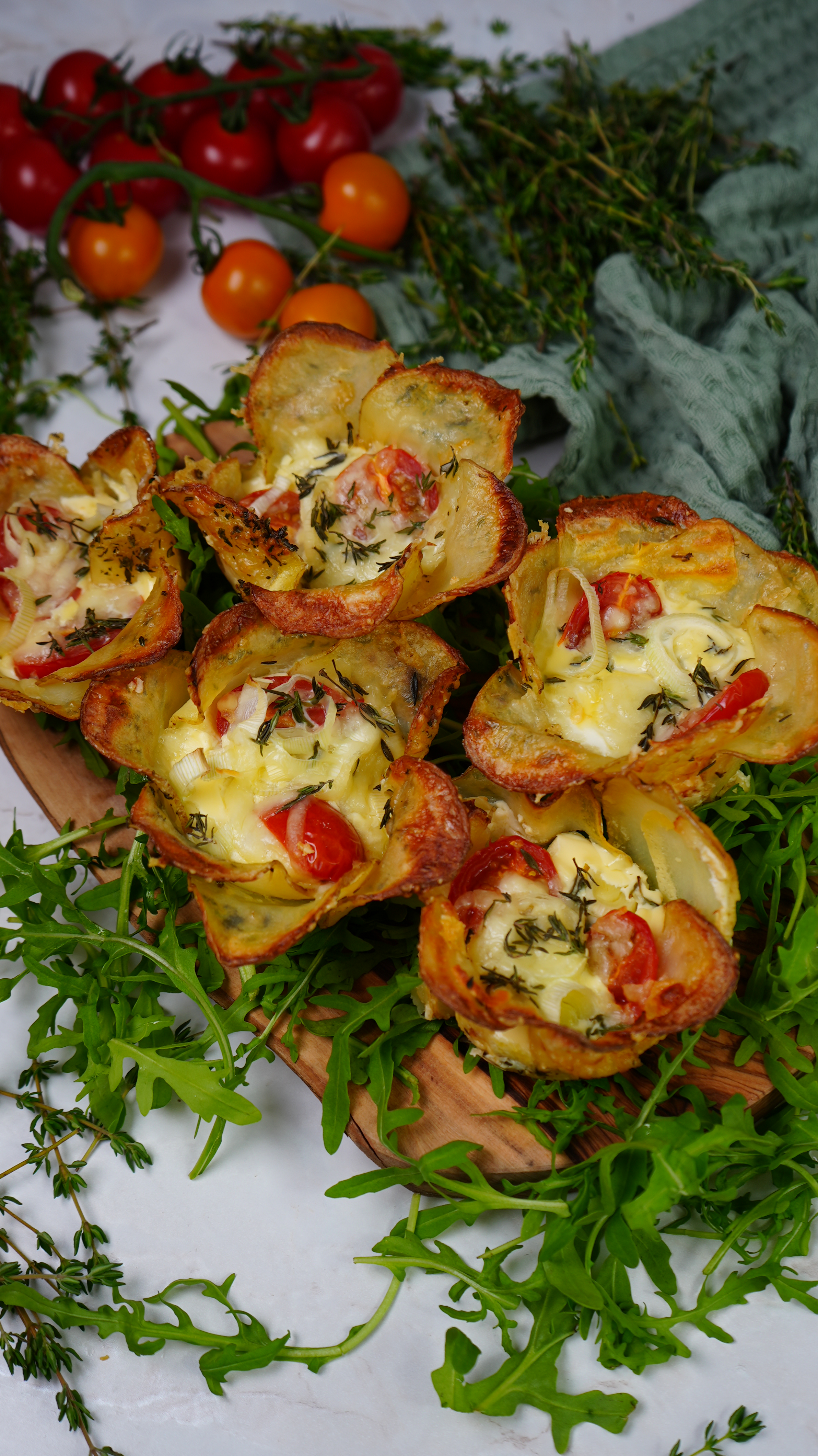 Beautifully baked potato cups filled with cheese and vegetables, garnished with fresh thyme.