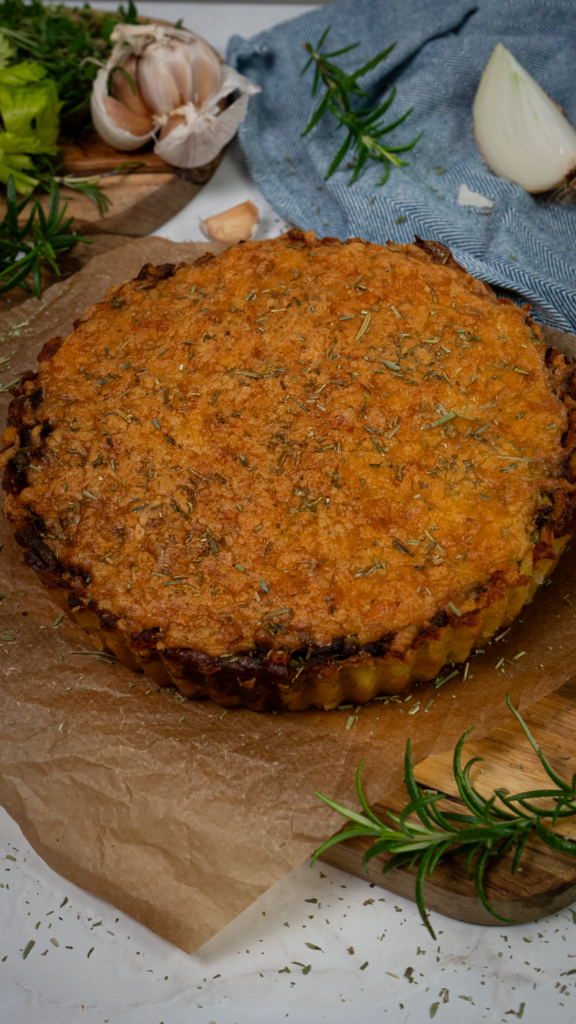 Crushed Potato Cottage Pie with a golden potato crust and hearty beef filling, garnished with fresh rosemary.