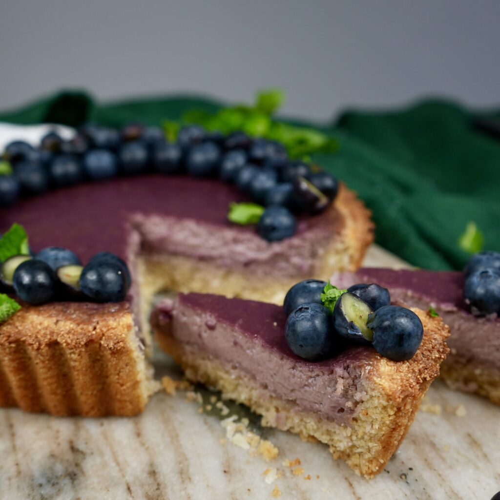 Sliced Berry Semolina Tart with blueberries and mint garnish