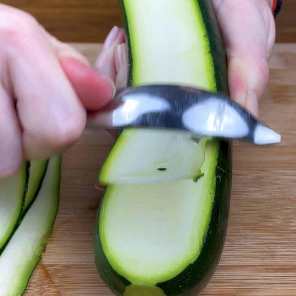 Slicing courgette into thin strips.