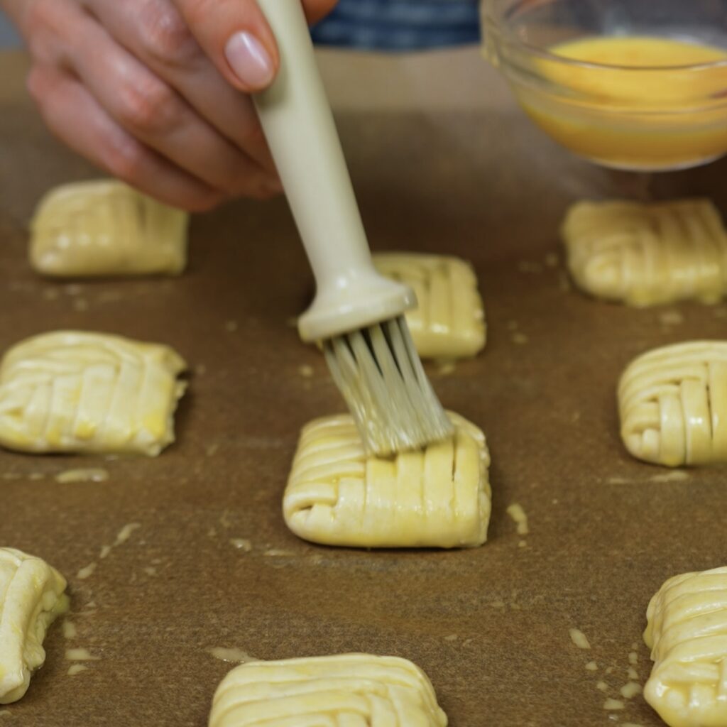 Brushing Pistachio Puffs with egg wash