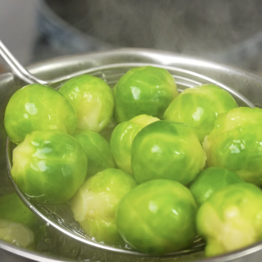 Removing boiled Brussels sprouts from hot water.