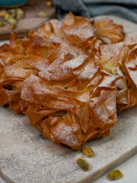 Golden filo pistachio buns dusted with icing sugar