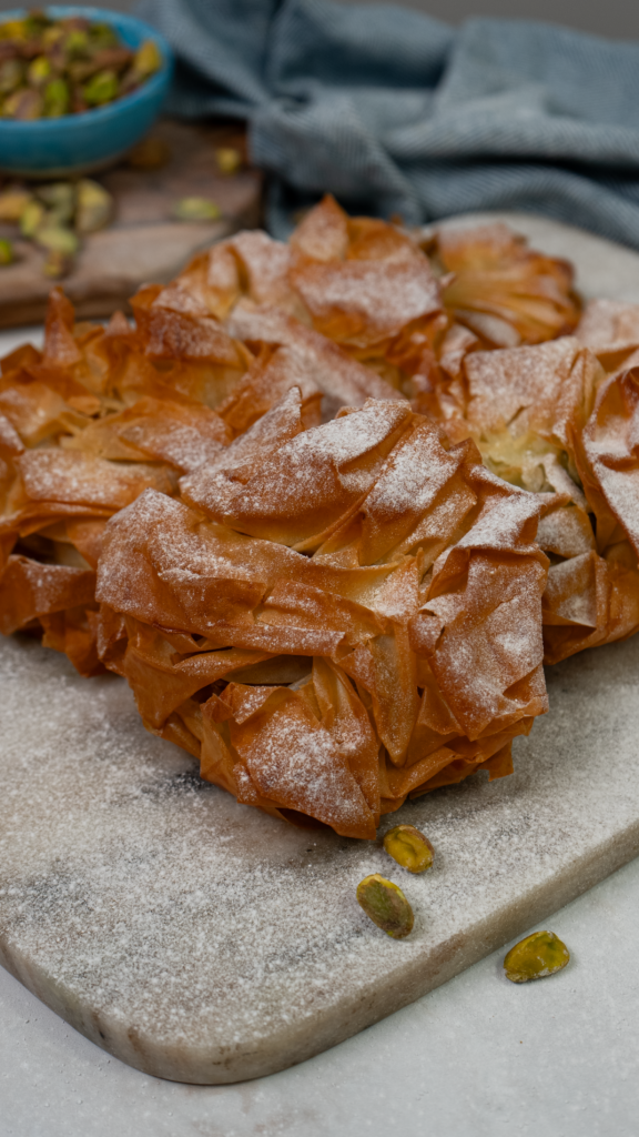 Golden filo pistachio buns dusted with icing sugar