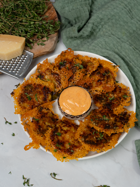 Smushed Brussels sprouts on a plate with sriracha mayo sauce.