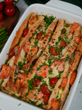 Golden-baked Salmon and Cherry Tomato Lavash Bake with chives garnish.