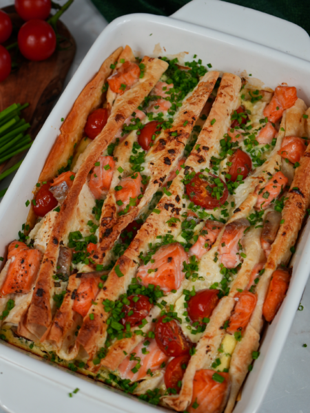 Golden-baked Salmon and Cherry Tomato Lavash Bake with chives garnish.