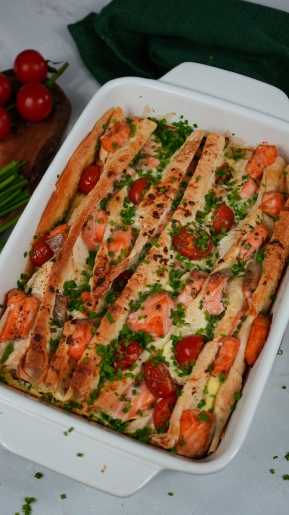 Golden-baked Salmon and Cherry Tomato Lavash Bake with chives garnish.