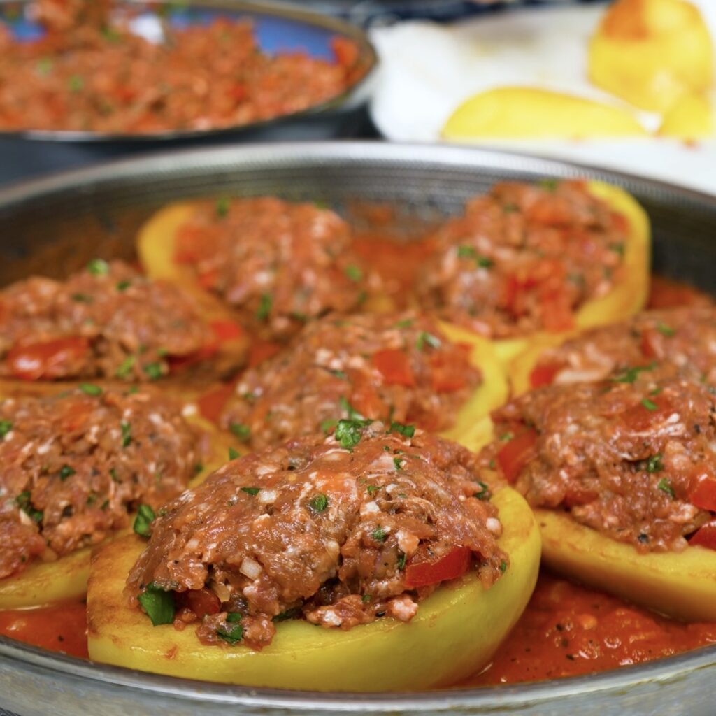 Potato boats filled with spiced minced meat mixture, ready for baking.