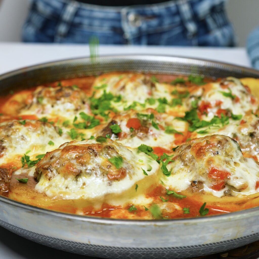 Garnishing stuffed potato boats with fresh coriander.