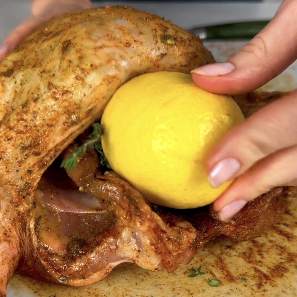 Stuffing the chicken with shallots, thyme, and a pierced lemon.