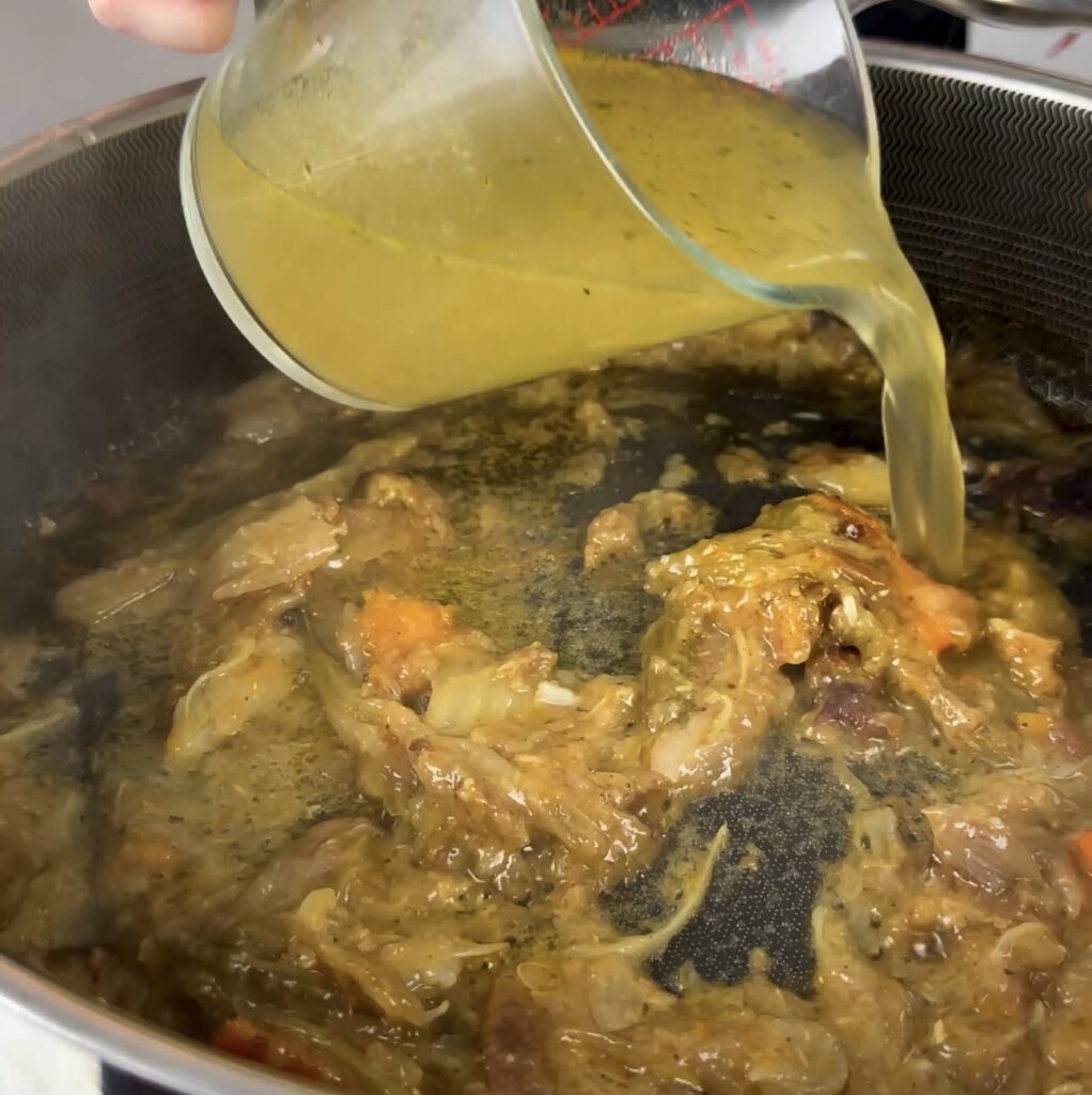 Adding chicken stock to the pan for the gravy.