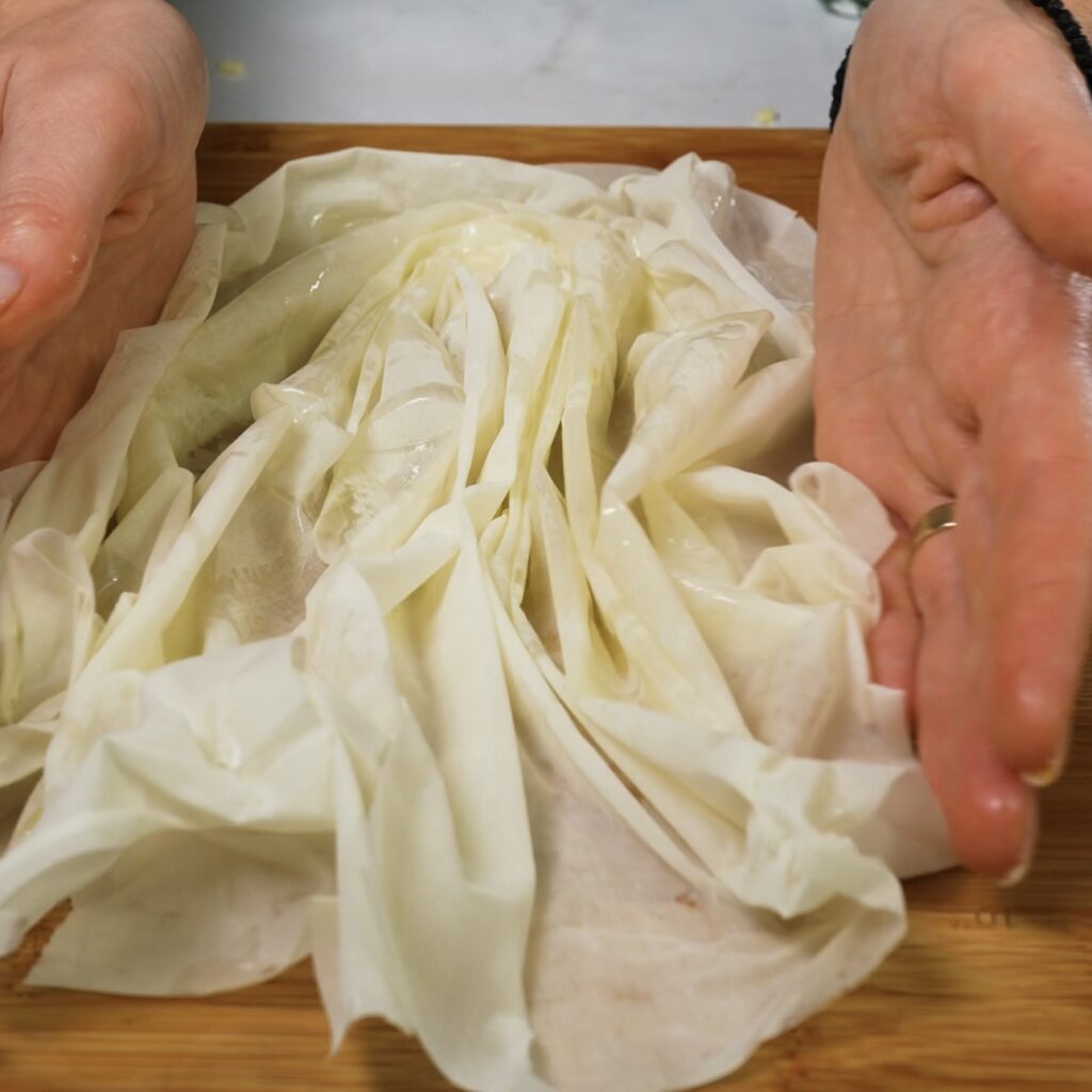 Gathering the sides of filo pastry towards the centre.