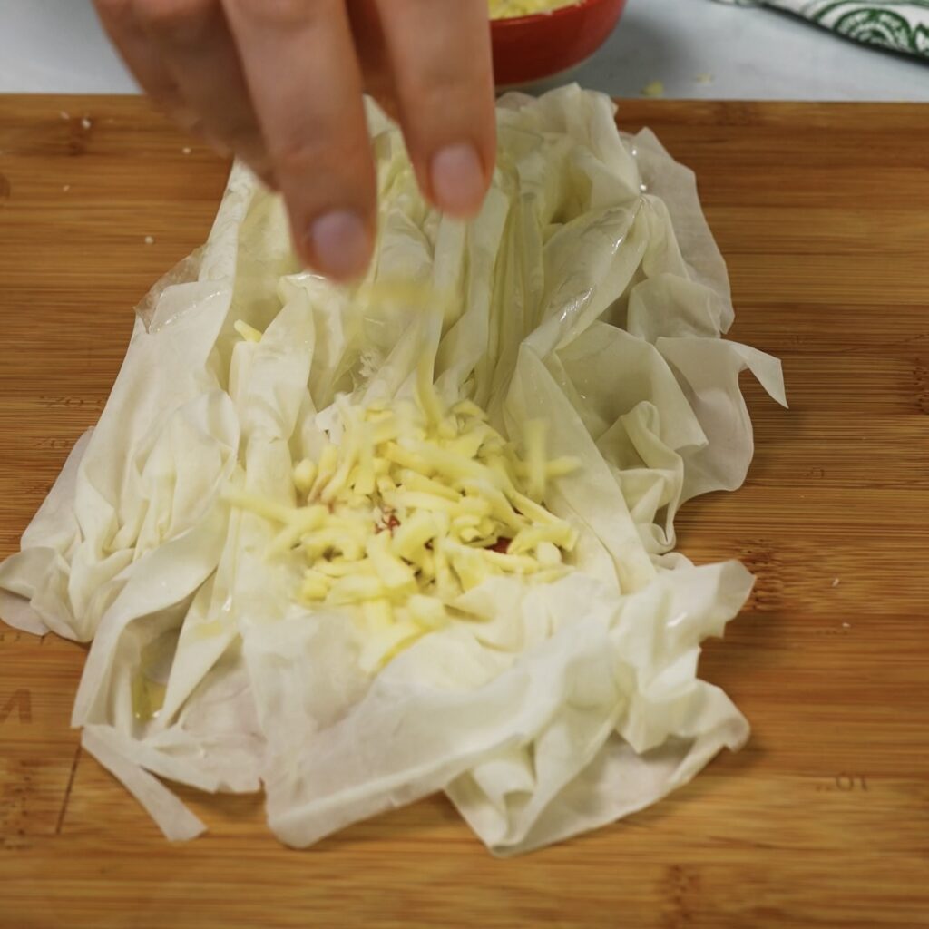 Adding pesto and cheese to filo pastry.