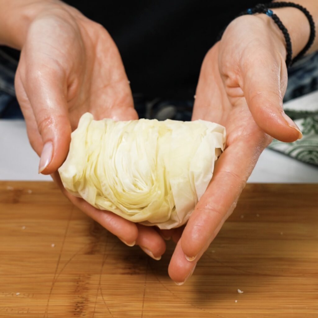 Flipping the rolled filo pastry to reveal the decorative top