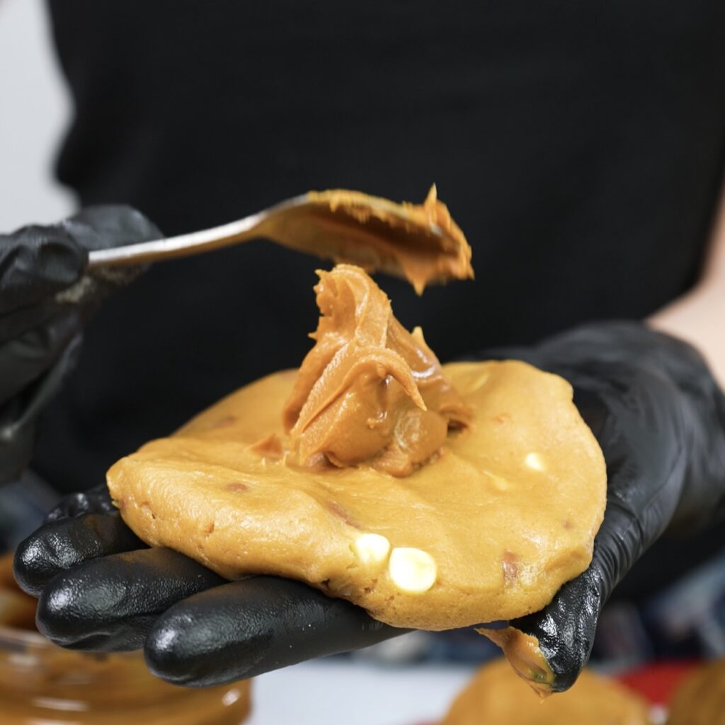 Adding Biscoff spread to chocolate chip cookie dough.