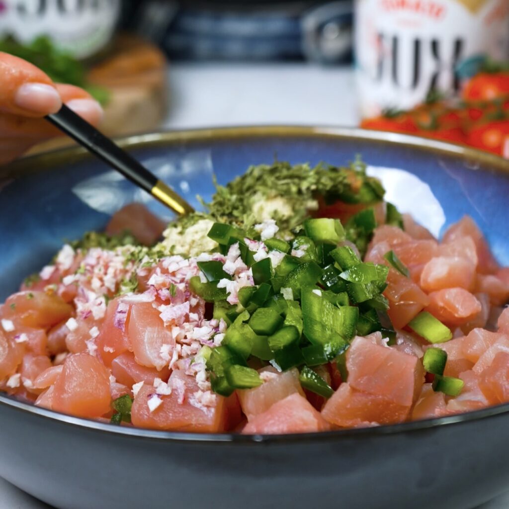 Mixing ingredients for tuna tartare in a bowl.