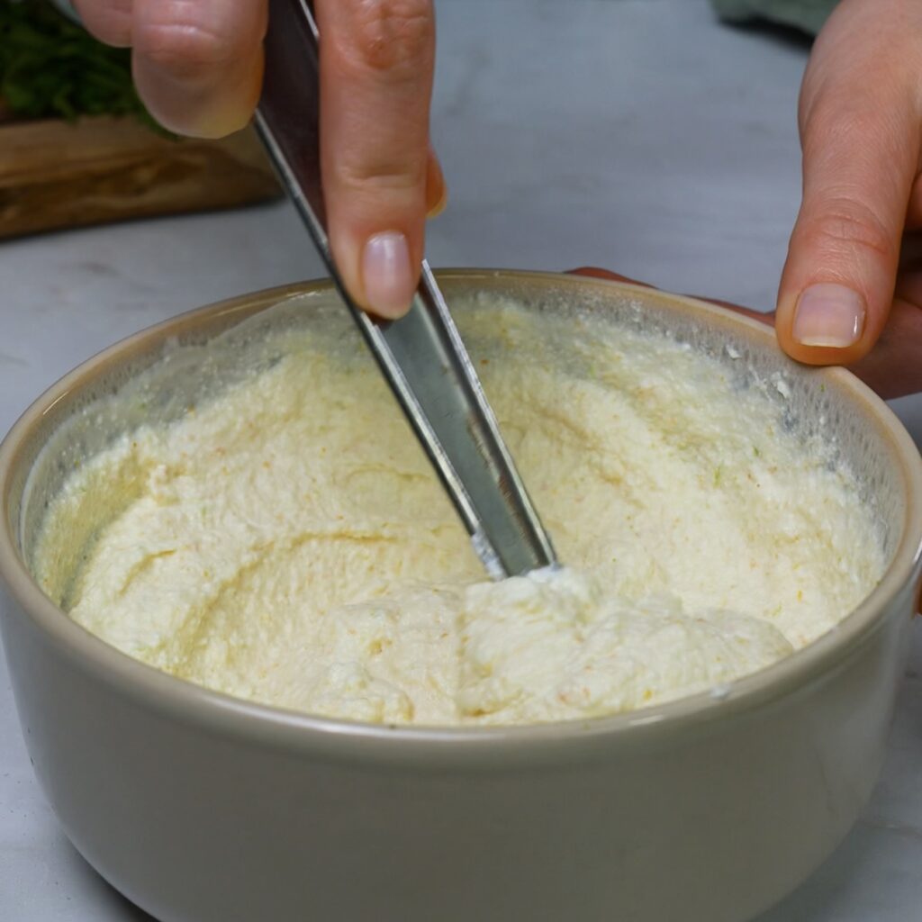 Mixing ricotta filling with yogurt and tomato powder.