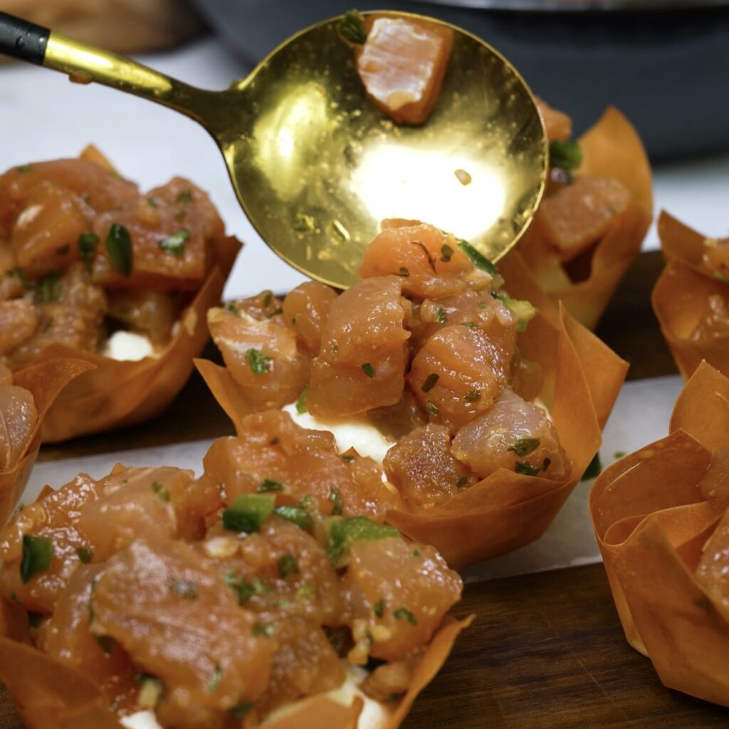 Assembling filo cups with ricotta and tuna tartare.