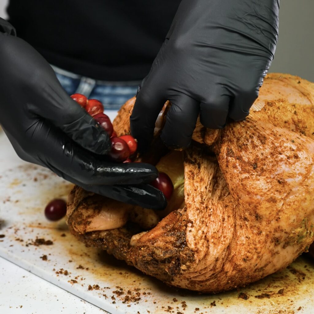 Stuffing the chicken with orange, cranberries, and fresh herbs