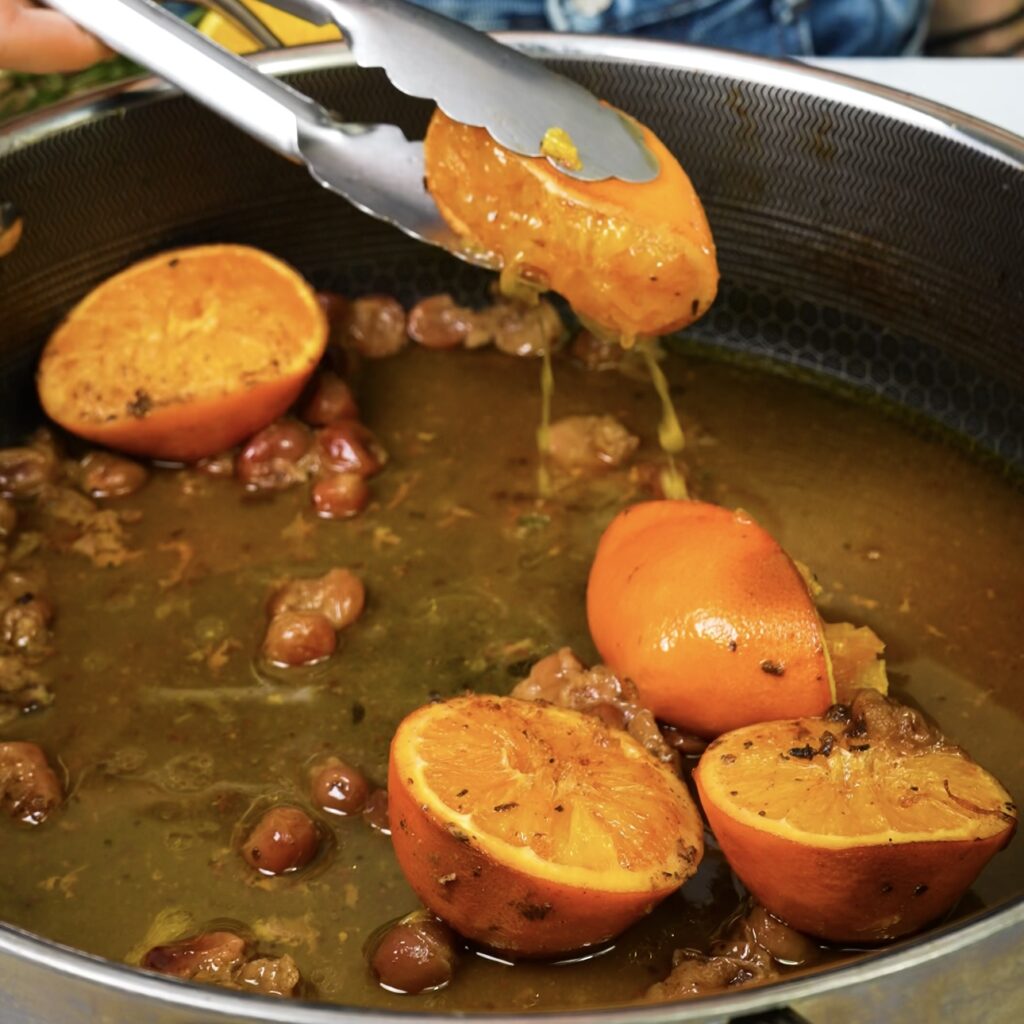 Squeezing roasted orange halves for gravy