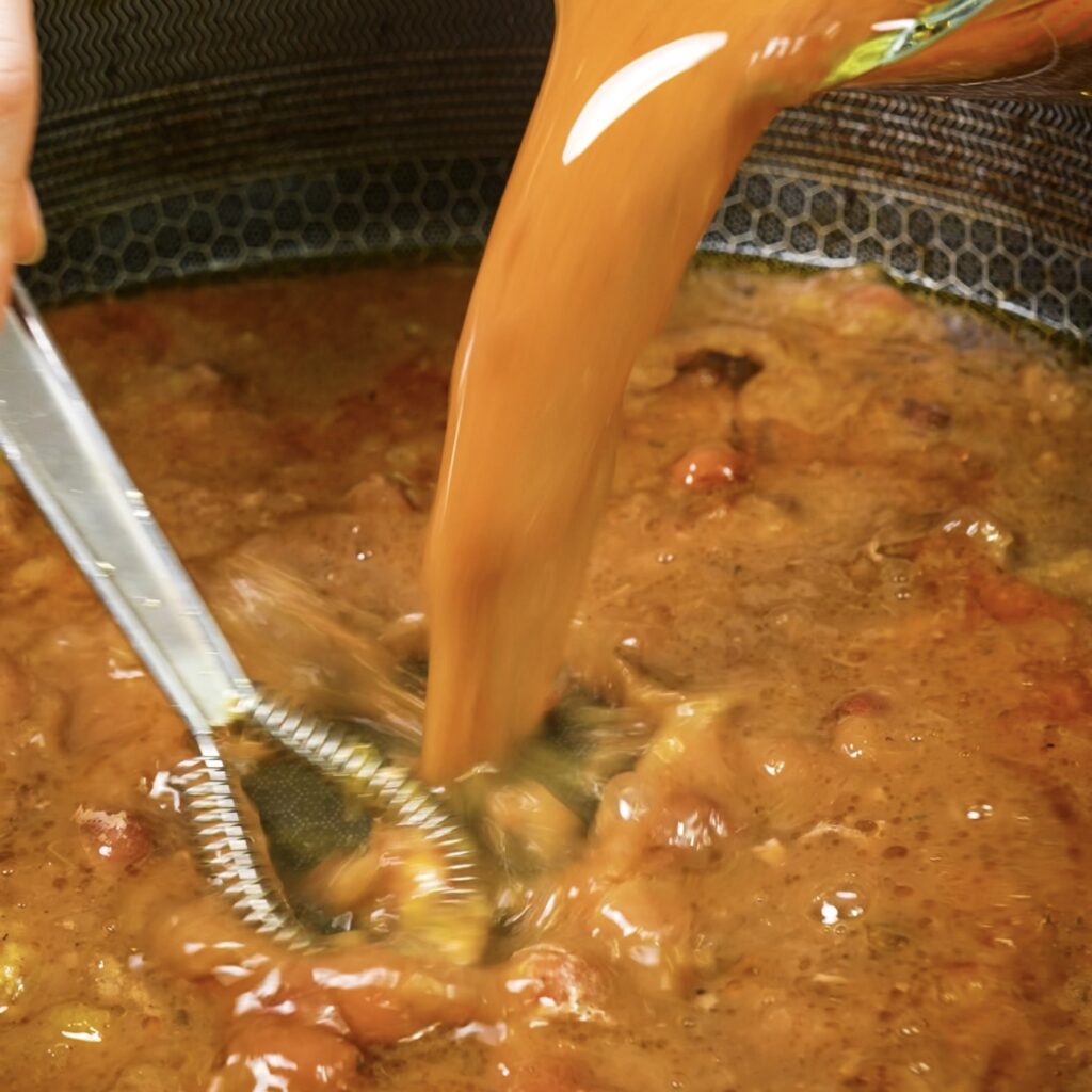 Making gravy with roasted chicken juices, orange juice, and cranberries