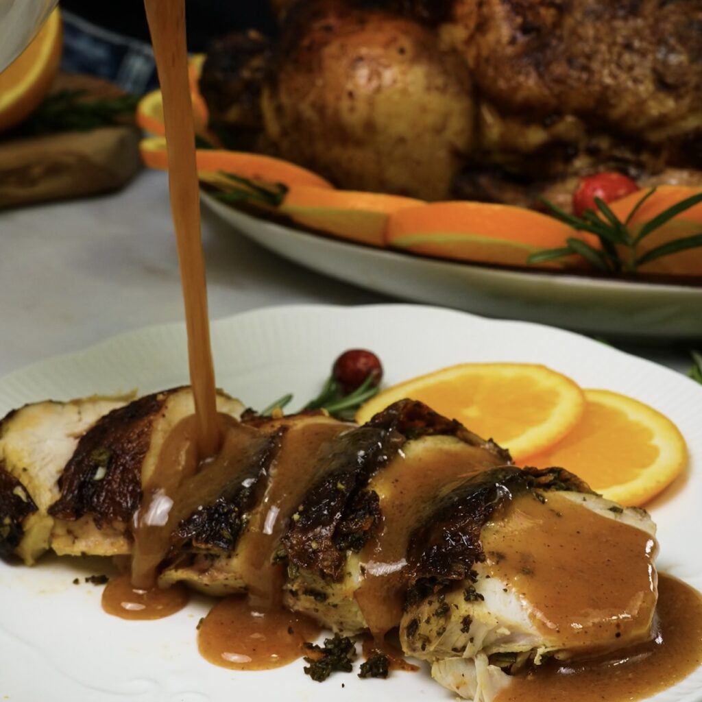 Gravy poured over roasted chicken, adding a glossy, savoury finish.