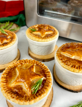 Golden Individual Christmas Pies topped with festive puff pastry decorations.