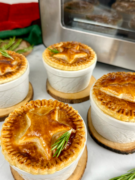 Golden Individual Christmas Pies topped with festive puff pastry decorations.