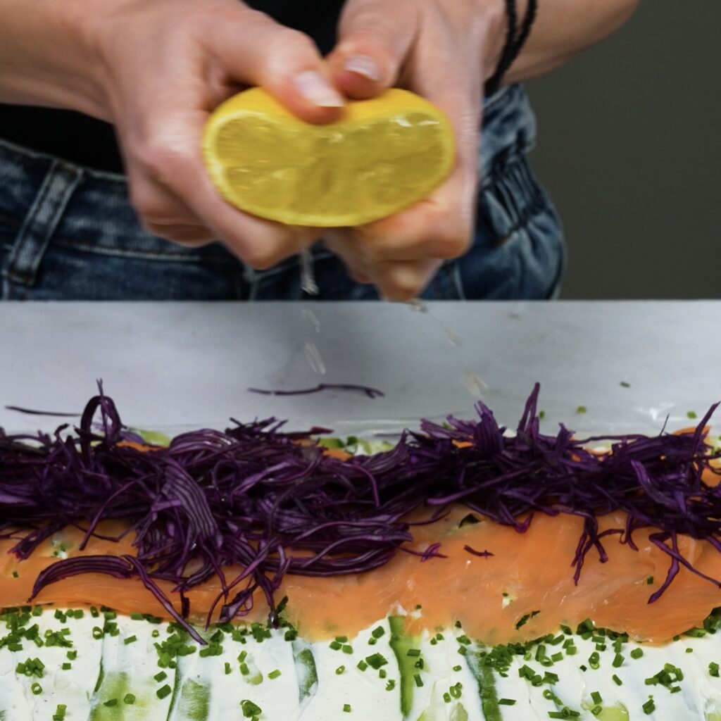 Drizzling lemon juice over red cabbage in the rice paper roll.