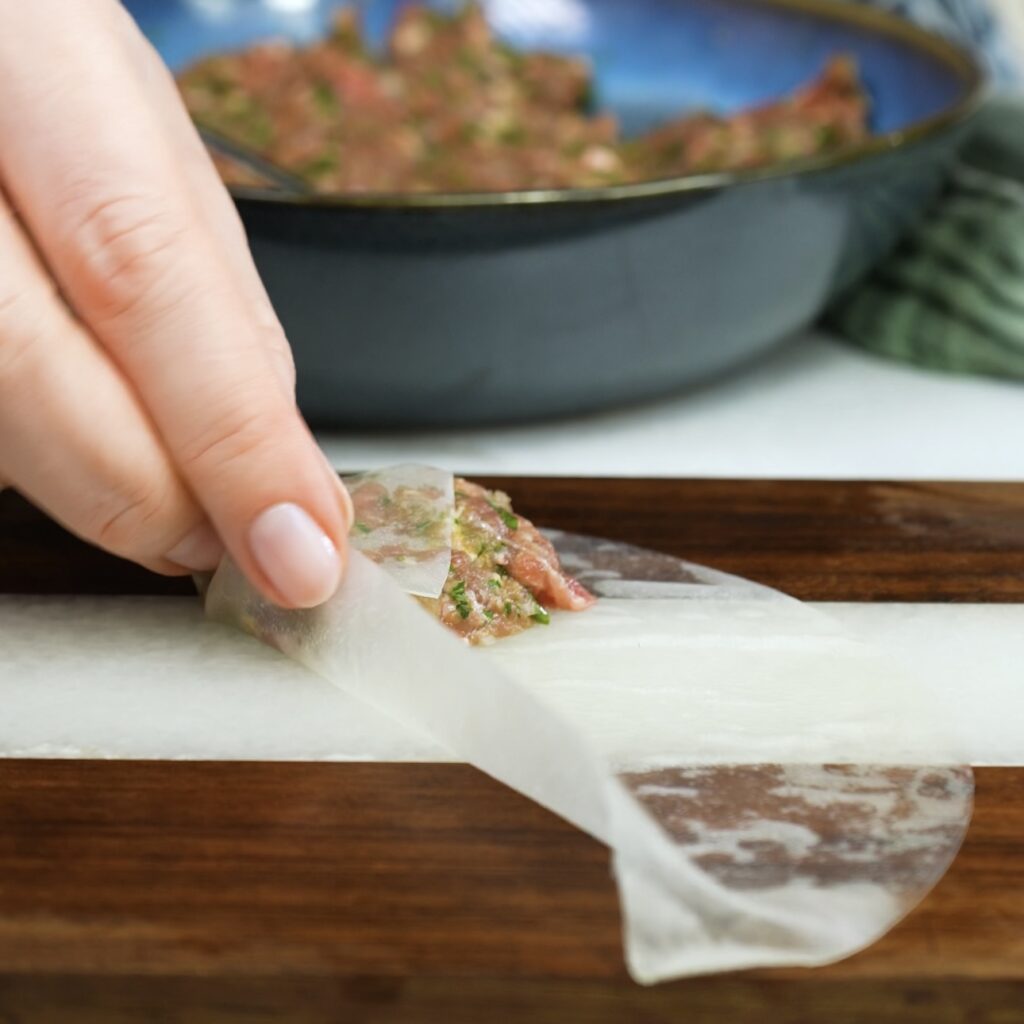 Folding rice paper to form parcels.