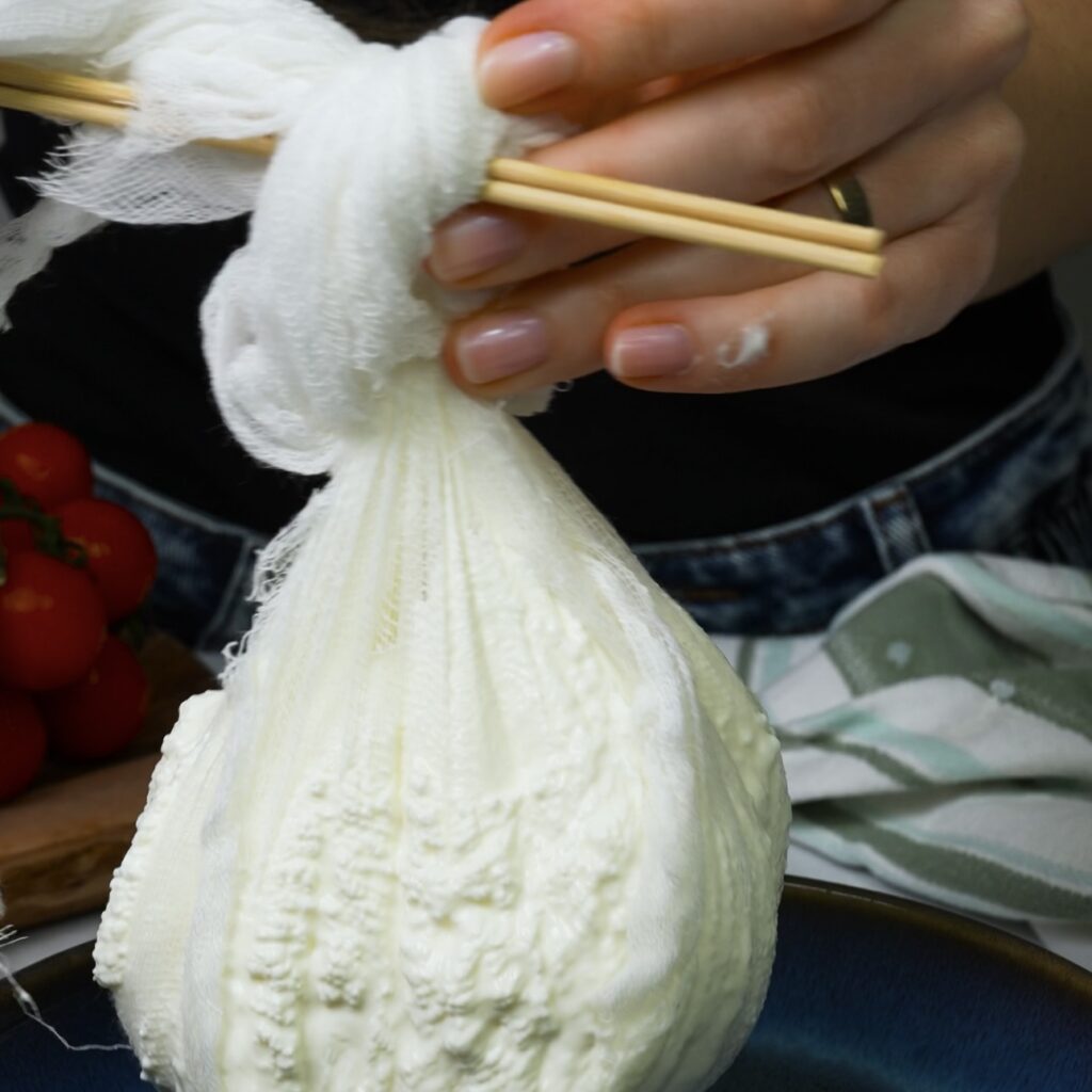 Straining yogurt in a cheesecloth to make labneh.