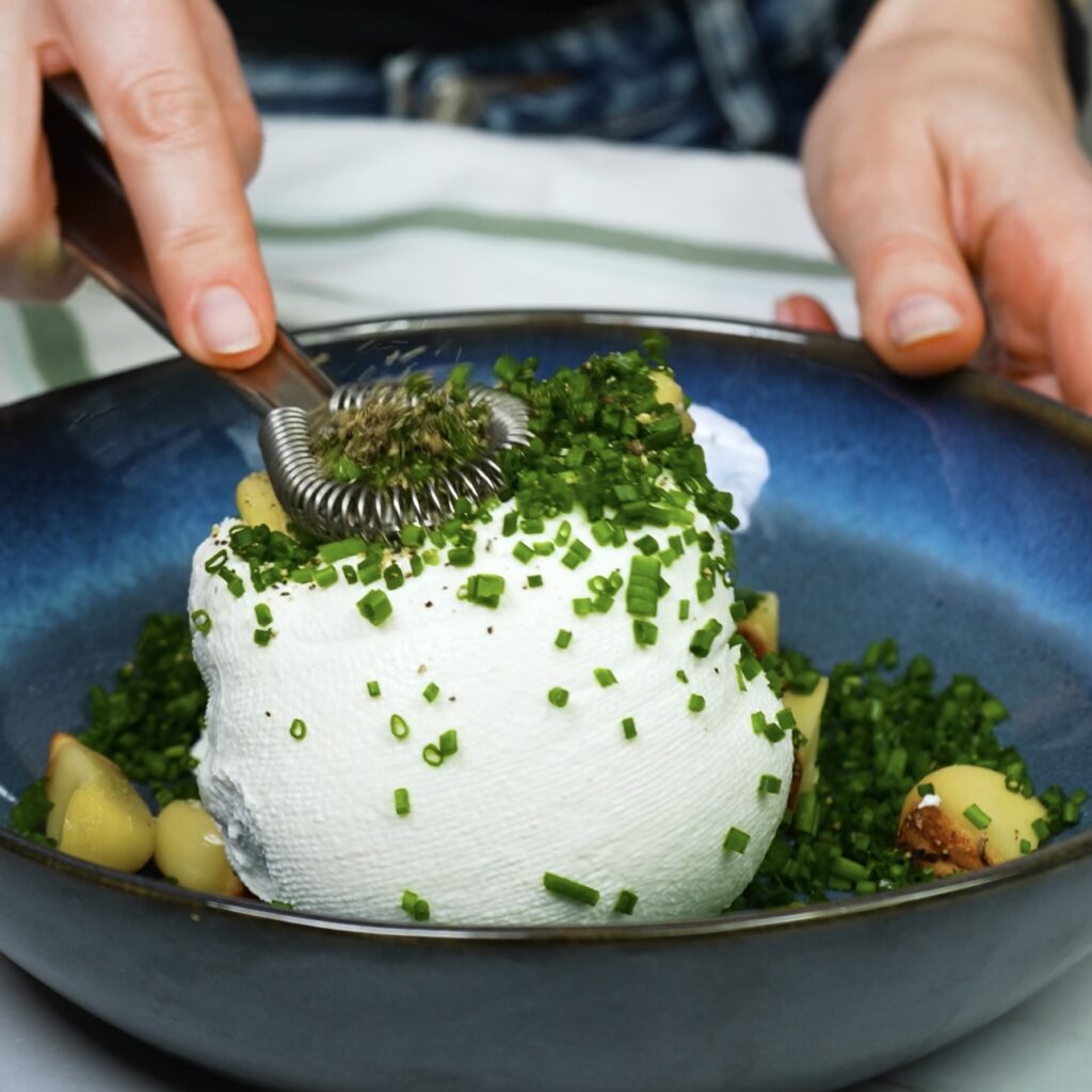 Mixing labneh with roasted garlic and chives.