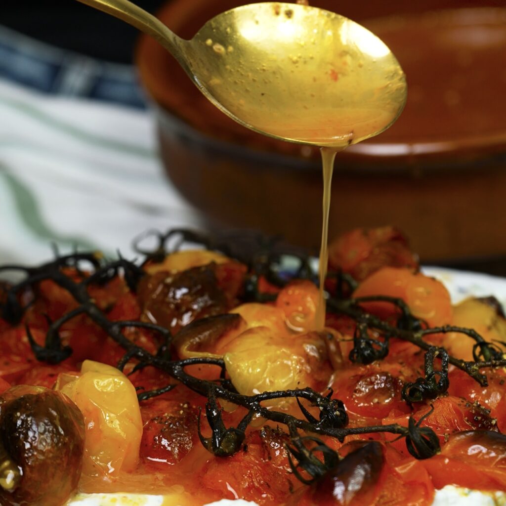 Drizzling roasted tomato juices over labneh dip.