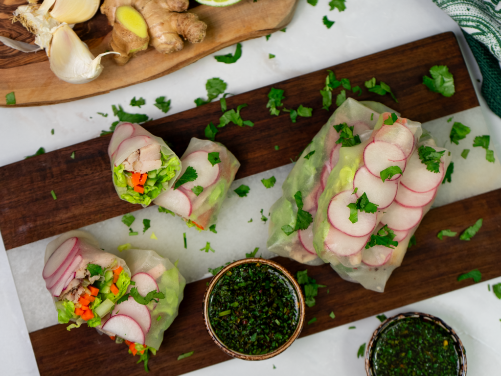 Chicken spring rolls on a wooden board.