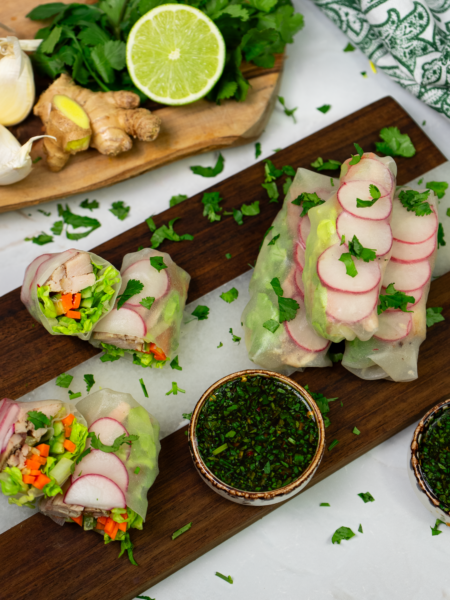 Chicken spring rolls on a wooden board.