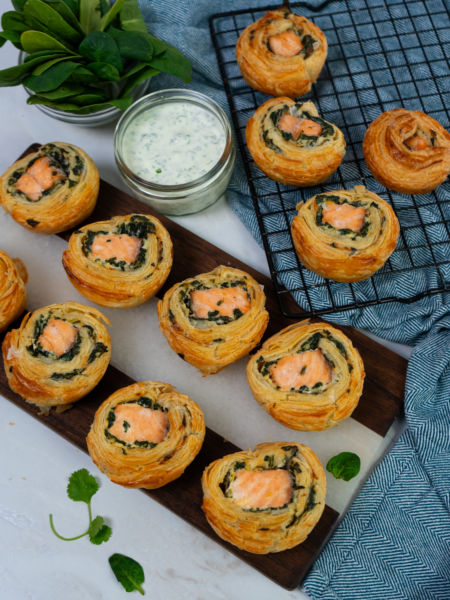 Freshly baked salmon and spinach puff pastry rolls with a golden, flaky crust.