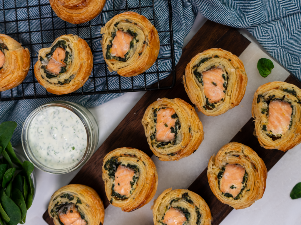 Freshly baked salmon and spinach puff pastry rolls with a golden, flaky crust.