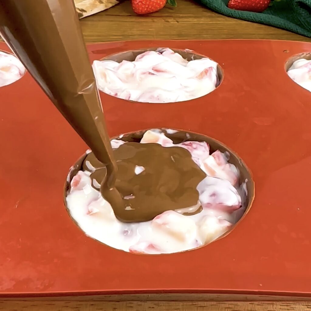 Sealing the strawberry yogurt filling with melted chocolate.