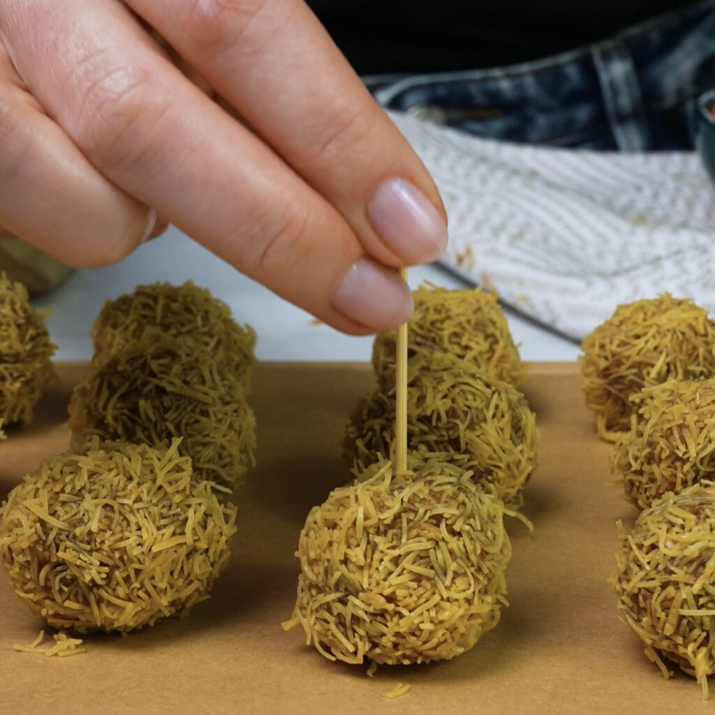 Inserting a toothpick into the rolled date mixture and freezing briefly.