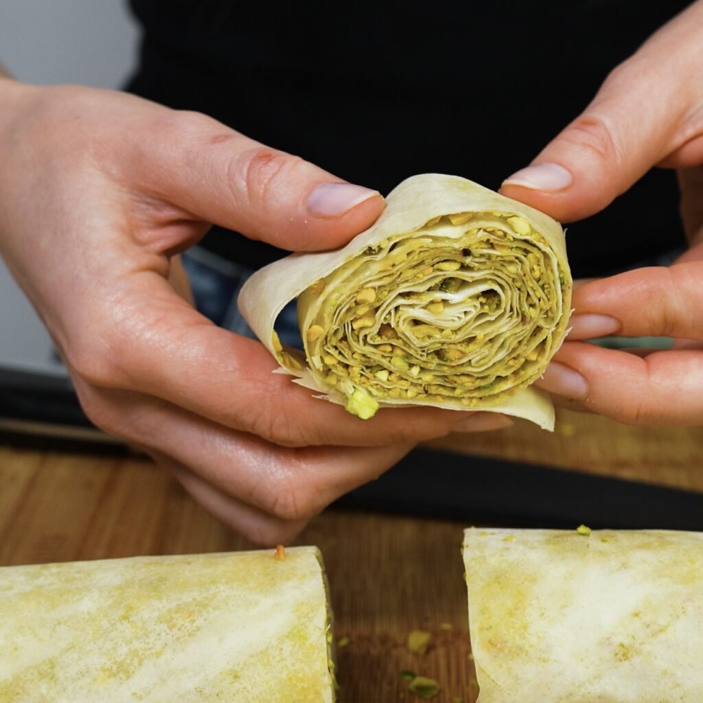 Rolled filo pastry with pistachio filling, sliced into small pieces.