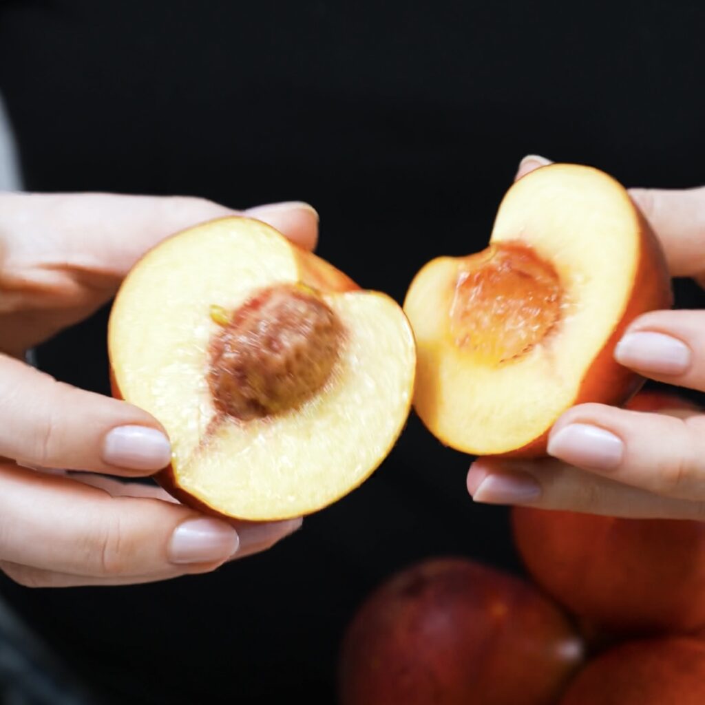 Fresh halved nectarines with vibrant orange flesh and deep red skin