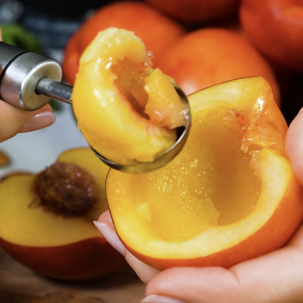 Halved nectarines with some flesh scooped out, creating a hollow centre for stuffing.